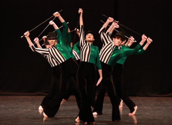 Dancers on stage performing a group piece with canes and bowler hats