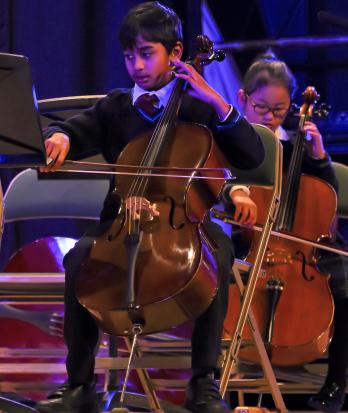 Prep School pupils playing as part of a strings group in a concert in the Hall