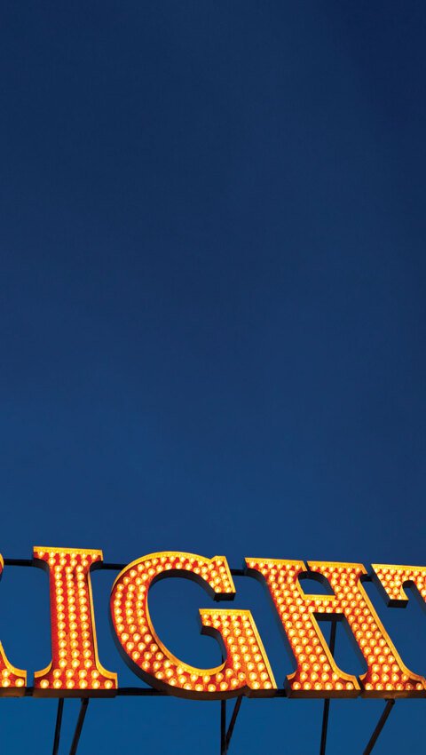 'Brighton' illuminated sign on Brighton Pier with their evening sky