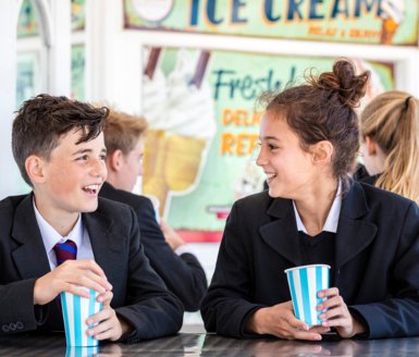  Lower School pupils sitting at a café on Brighton Pier enjoying milkshakes together 