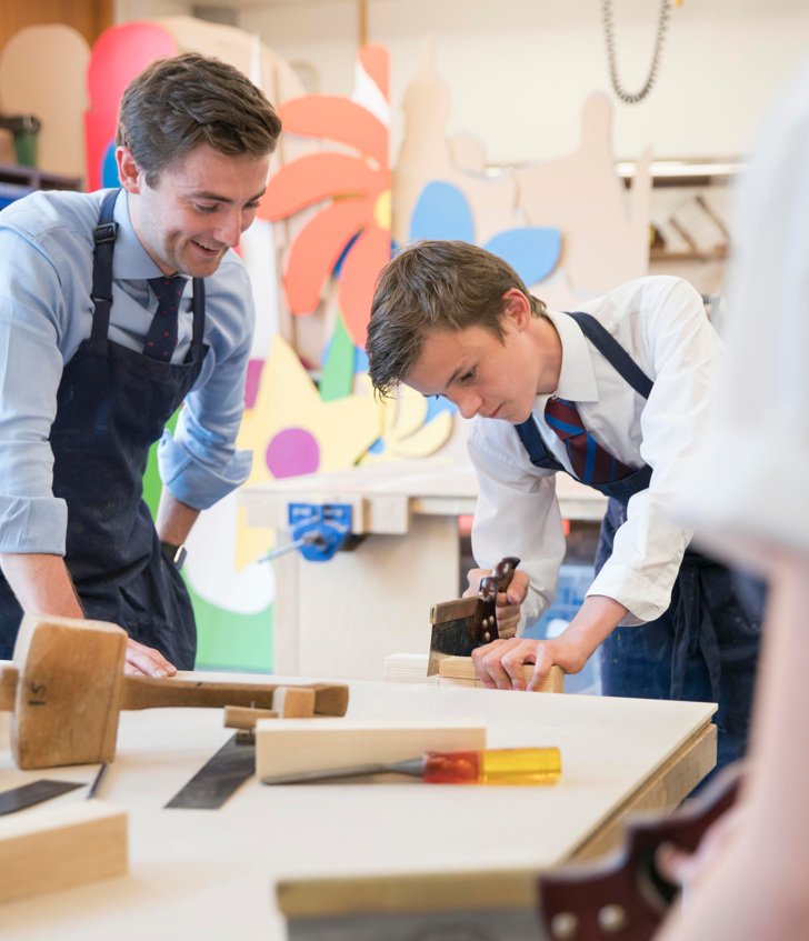  Pupil using a saw being supervised by a teacher in a Design and Technology lesson 