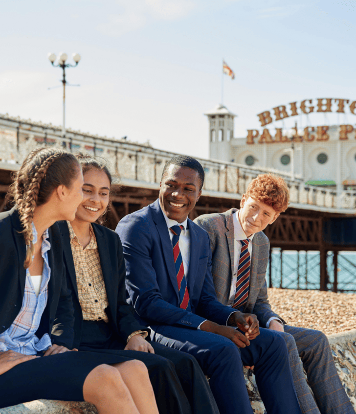 Sixth form pupils enjoying themselves on the beach in front of Brighton Pier 
