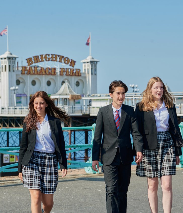  Pupils enjoying walking along the seafront together in uniform in front of the Pier 
