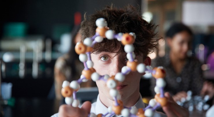  A-Level pupil examining a model of a molecular structure in a Chemistry lesson 