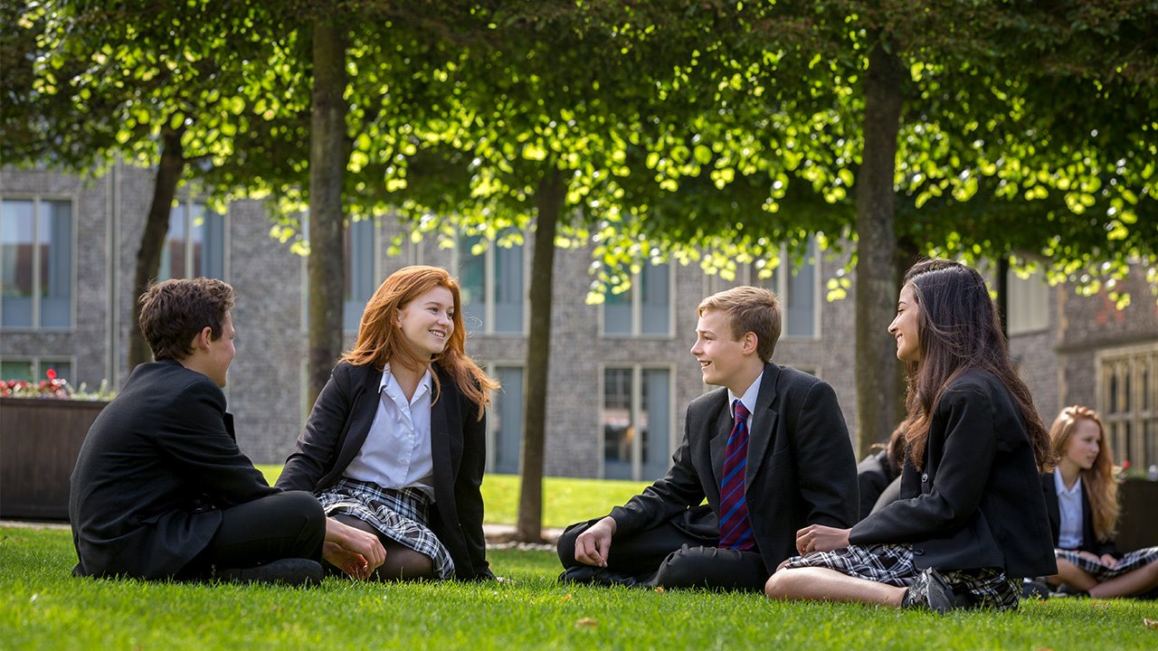 Brighton-College-co-ed-pupils-sitting-on-grass.jpg
