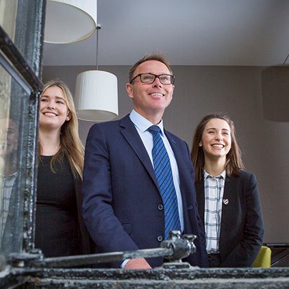 Head master smiling in window with pupils trio nav square.jpg